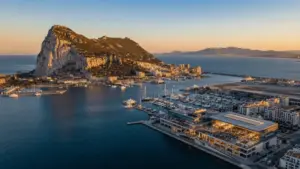 Aerial view of Gibraltar rock and harbor at sunset with modern conference venue