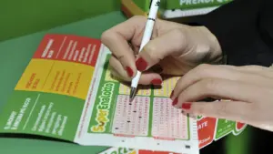 Close-up of a person using a pen to mark numbers on a SuperEnalotto lottery ticket
